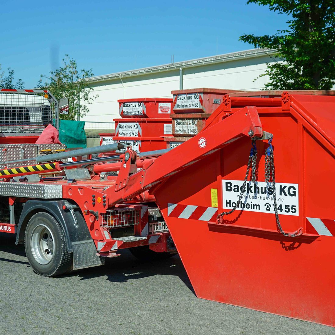 LKW wird mit einem roten Container der Backhus KG beladen.